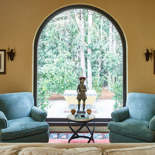 Großes, Repräsentatives, Fernseherloses, Abgetrenntes Mediterranes Wohnzimmer mit beiger Wandfarbe, dunklem Holzboden, Kamin, gefliestem Kaminsims und braunem Boden in Los Angeles