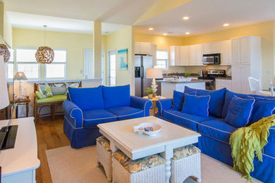 Example of a mid-sized beach style formal and open concept medium tone wood floor and brown floor living room design in Other with beige walls, no fireplace and a tv stand