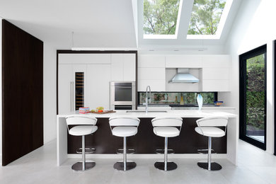 Contemporary kitchen in Toronto with an undermount sink, white cabinets, window splashback, panelled appliances, with island and white floor.