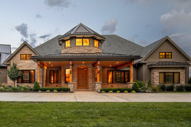 Huge traditional brown two-story stone and board and batten exterior home idea in Other with a shingle roof and a gray roof