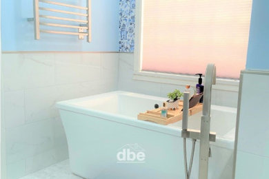 Mid-sized beach style master white tile and porcelain tile mosaic tile floor, white floor, single-sink and wallpaper bathroom photo in Other with shaker cabinets, brown cabinets, a bidet, blue walls, an undermount sink, quartz countertops, a hinged shower door, white countertops and a built-in vanity