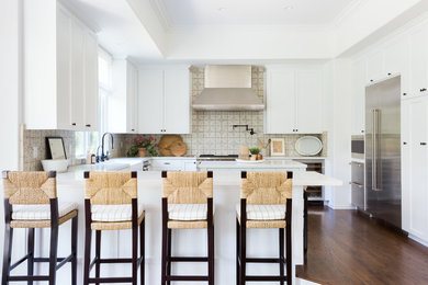 Kitchen - coastal u-shaped dark wood floor and brown floor kitchen idea in Los Angeles with a farmhouse sink, shaker cabinets, white cabinets, multicolored backsplash, stainless steel appliances, a peninsula and white countertops