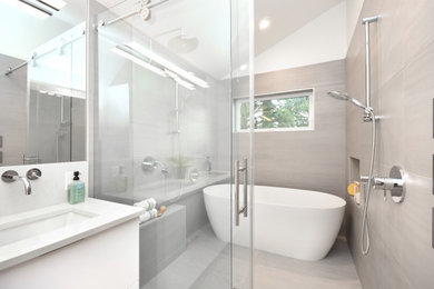 Example of a mid-sized trendy master gray tile and porcelain tile double-sink, vinyl floor and brown floor bathroom design in Seattle with flat-panel cabinets, white cabinets, an undermount sink, quartz countertops, white countertops, a built-in vanity, a one-piece toilet and white walls
