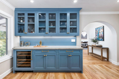 Inspiration for a mid-sized farmhouse single-wall medium tone wood floor and brown floor home bar remodel in San Francisco with blue cabinets, quartz countertops, blue backsplash, wood backsplash and gray countertops