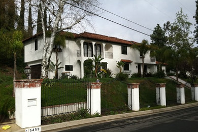 Inspiration for a large mediterranean white two-story stone exterior home remodel in Los Angeles