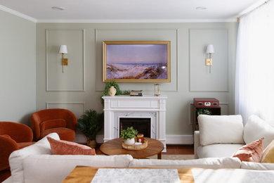 Mid-sized transitional open concept medium tone wood floor living room photo in Providence with green walls, a standard fireplace and a wall-mounted tv