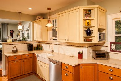 Inspiration for a country l-shaped medium tone wood floor eat-in kitchen remodel in Detroit with white backsplash, subway tile backsplash, stainless steel appliances, a farmhouse sink, raised-panel cabinets, yellow cabinets, limestone countertops and a peninsula