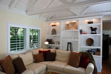 Inspiration for a mid-sized cottage open concept medium tone wood floor family room remodel in San Francisco with yellow walls, a standard fireplace, a stone fireplace and a wall-mounted tv
