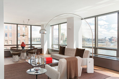 Mid-sized trendy open concept medium tone wood floor family room photo in New York with white walls, no fireplace and a wall-mounted tv