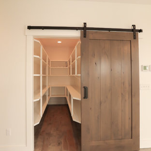 Cette photo montre une arrière-cuisine craftsman de taille moyenne avec un placard sans porte, des portes de placard blanches, un plan de travail en bois et un sol en bois clair.