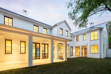 Large elegant white two-story stucco gable roof photo in Dallas