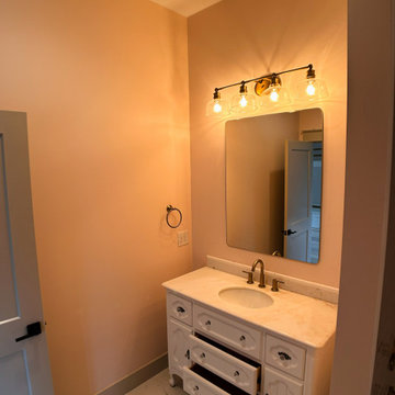 Elegant Guest Bath: Soft Terracotta Walls, Marble Vanity, and Modern Black Fixtu