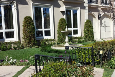 This is an example of a mid-sized traditional full sun front yard water fountain landscape in Los Angeles.