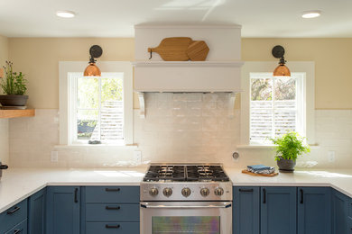 Small arts and crafts u-shaped porcelain tile and gray floor enclosed kitchen photo in Seattle with an undermount sink, shaker cabinets, blue cabinets, quartz countertops, white backsplash, porcelain backsplash, stainless steel appliances and no island