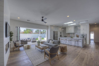 Example of a large minimalist medium tone wood floor kitchen design in Phoenix with a farmhouse sink, shaker cabinets, marble countertops, gray backsplash, marble backsplash, stainless steel appliances and an island
