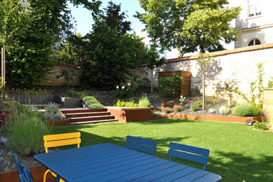 Cette image montre un petit jardin minimaliste avec une pente, une colline ou un talus et une clôture en pierre.