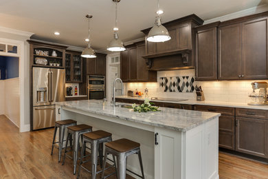 Mid-sized transitional u-shaped light wood floor and beige floor eat-in kitchen photo in Raleigh with an undermount sink, recessed-panel cabinets, granite countertops, white backsplash, ceramic backsplash, stainless steel appliances, an island and dark wood cabinets