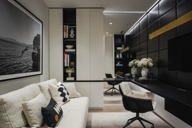 Small trendy built-in desk light wood floor, white floor and wall paneling study room photo in New York with white walls