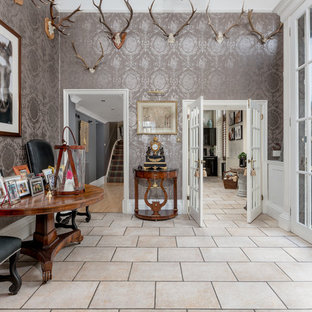 Cette image montre un hall d'entrée bohème avec mur métallisé, une porte double, un sol beige et une porte en verre.