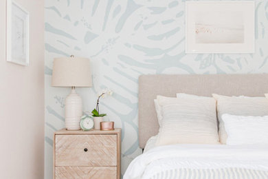 Imagen de habitación de invitados marinera de tamaño medio con paredes azules, suelo de madera clara, suelo marrón y papel pintado