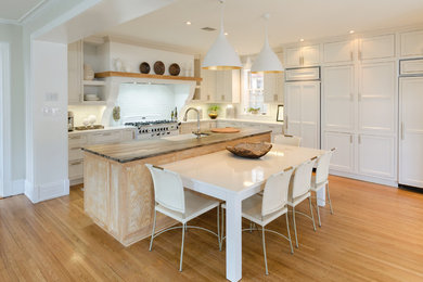 Inspiration for a large transitional kitchen in Richmond with a farmhouse sink, shaker cabinets, white cabinets, quartzite benchtops, white splashback, ceramic splashback, panelled appliances, medium hardwood floors, with island and brown floor.