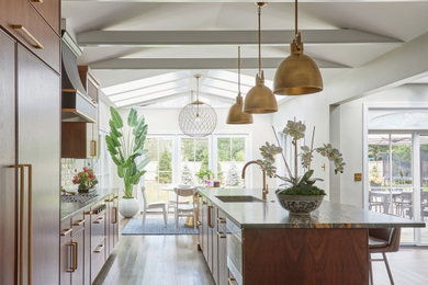 Large transitional single-wall medium tone wood floor kitchen photo in Chicago with an undermount sink, flat-panel cabinets, medium tone wood cabinets, quartzite countertops, white backsplash, porcelain backsplash, an island and black countertops