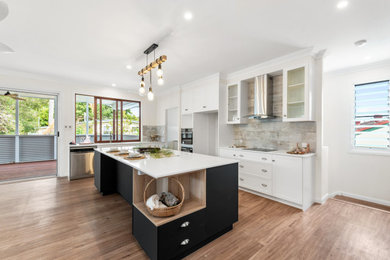 Inspiration for a large contemporary l-shaped open plan kitchen in Brisbane with an undermount sink, shaker cabinets, white cabinets, solid surface benchtops, multi-coloured splashback, cement tile splashback, stainless steel appliances, vinyl floors, with island and white benchtop.