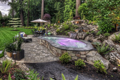Example of a small transitional backyard stone and kidney-shaped aboveground pool fountain design in Orange County