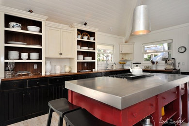Example of a large arts and crafts l-shaped light wood floor eat-in kitchen design in Vancouver with beige cabinets, an island, a double-bowl sink and open cabinets