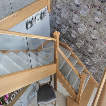 Modern staircase with a mix of glass and natural oak and carpeted treads