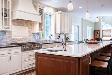 Inspiration for a large transitional u-shaped dark wood floor eat-in kitchen remodel in New York with an undermount sink, raised-panel cabinets, white cabinets, marble countertops, gray backsplash, an island, subway tile backsplash and paneled appliances