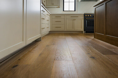 Inspiration for a modern medium tone wood floor and brown floor eat-in kitchen remodel in Other with shaker cabinets, light wood cabinets, quartz countertops, white backsplash, quartz backsplash, an island and white countertops