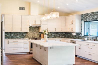 Inspiration for a contemporary l-shaped dark wood floor, brown floor and vaulted ceiling kitchen remodel in San Diego with an undermount sink, flat-panel cabinets, white cabinets, multicolored backsplash, mosaic tile backsplash, stainless steel appliances, an island and white countertops