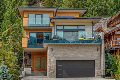 Large trendy beige three-story mixed siding exterior home photo in Other