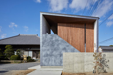 Ejemplo de fachada de casa gris y gris moderna de tamaño medio de dos plantas con revestimiento de madera, tejado de un solo tendido, tejado de metal y panel y listón