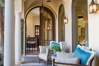 Mid-sized tuscan stone back porch idea in Dallas with a roof extension
