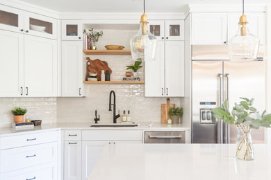 Open concept kitchen - mid-sized modern open concept kitchen idea in Other with a drop-in sink, shaker cabinets, white cabinets, quartz countertops, white backsplash, ceramic backsplash, stainless steel appliances, an island and white countertops