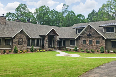 Example of a huge arts and crafts green two-story mixed siding exterior home design in Raleigh with a mixed material roof