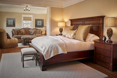 Inspiration for a large traditional master bedroom in Calgary with beige walls, medium hardwood floors, no fireplace and brown floor.