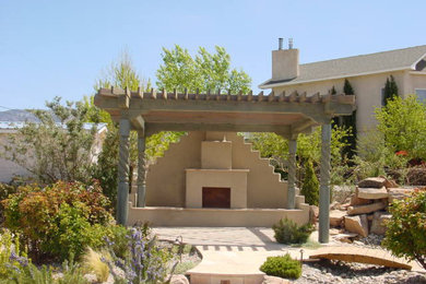 Mid-sized southwest backyard concrete patio photo in Albuquerque with a pergola
