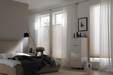 Mittelgroßes Modernes Schlafzimmer ohne Kamin mit grauer Wandfarbe und braunem Holzboden in Essen