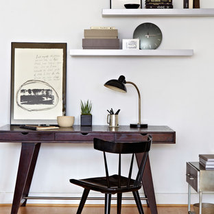 Inspiration for a mid-sized contemporary home office in New York with white walls, a freestanding desk and medium hardwood floors.