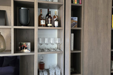This is an example of a small contemporary study in London with beige walls, vinyl flooring, a built-in desk and beige floors.
