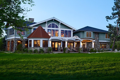 Large elegant green two-story wood exterior home photo in Denver