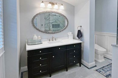 Example of a large master blue tile and porcelain tile porcelain tile, gray floor, single-sink and wainscoting bathroom design in Philadelphia with shaker cabinets, blue cabinets, a bidet, blue walls, an undermount sink, quartz countertops, white countertops, a niche and a freestanding vanity