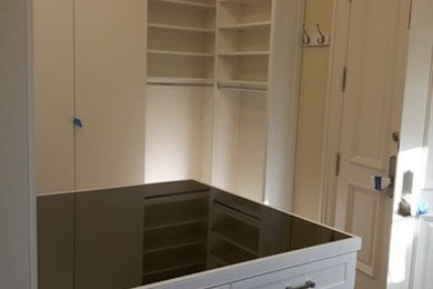 Design ideas for a gender-neutral walk-in wardrobe in Miami with recessed-panel cabinets, white cabinets and dark hardwood floors.