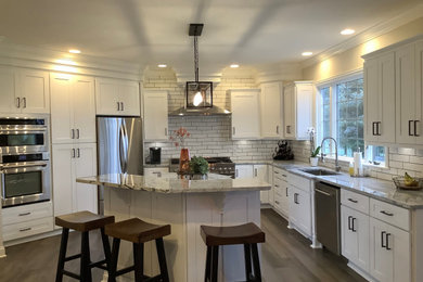 Inspiration for a huge modern u-shaped laminate floor, gray floor and wood ceiling kitchen remodel in Cleveland with an undermount sink, shaker cabinets, white cabinets, granite countertops, white backsplash, ceramic backsplash, stainless steel appliances, an island and gray countertops