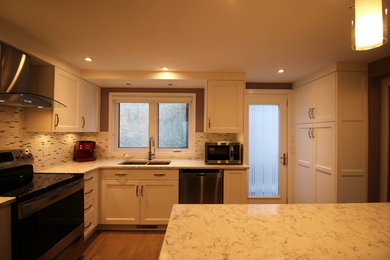 Enclosed kitchen - small transitional l-shaped light wood floor enclosed kitchen idea in Calgary with an undermount sink, shaker cabinets, white cabinets, quartzite countertops, multicolored backsplash, stone tile backsplash, white appliances and a peninsula