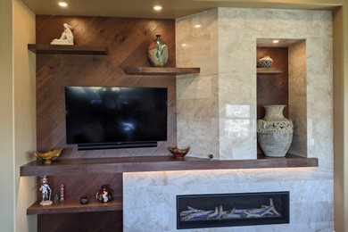 Mittelgroßes, Offenes Klassisches Wohnzimmer mit braunem Holzboden, unterschiedlichen Kaminen, Kaminumrandung aus Stein, TV-Wand und Holzwänden in Phoenix