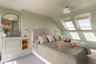 Small contemporary master loft bedroom in Sussex with green walls, carpet, beige floors and panelled walls.
